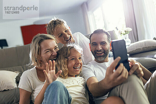 Fröhliche Familie macht zu Hause ein Selfie mit dem Handy