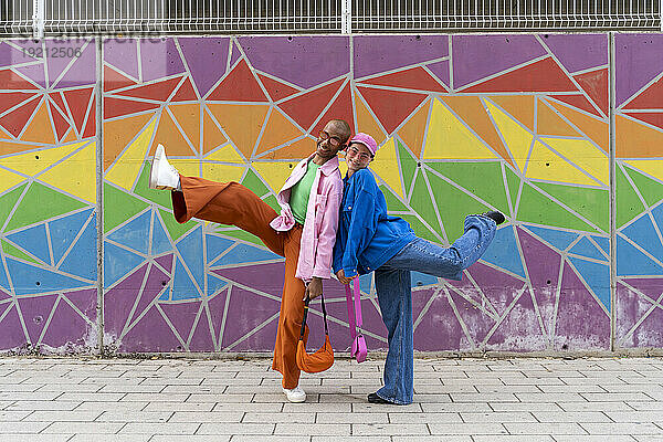 Smiling couple enjoying in front of colorful wall