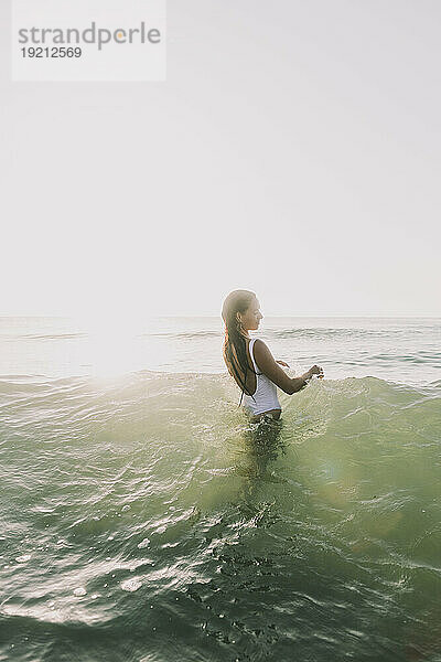 Frau spielt am Strand im Wasser