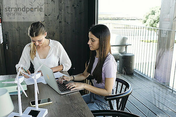 Zwei junge Ingenieurinnen arbeiten am Schreibtisch an einem nachhaltigen Energieprojekt