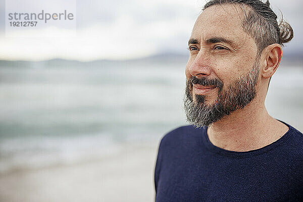 Nachdenklicher Mann mit Bart am Strand