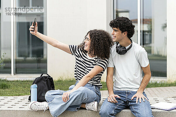 Glückliche Studenten machen Selfie vor dem Gebäude