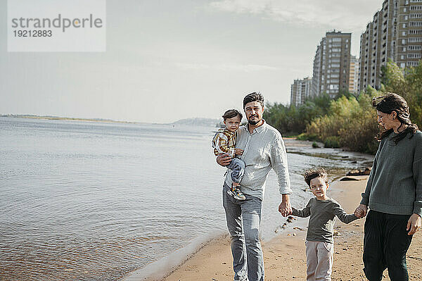Glückliche Familie  die zusammen am Strand spaziert