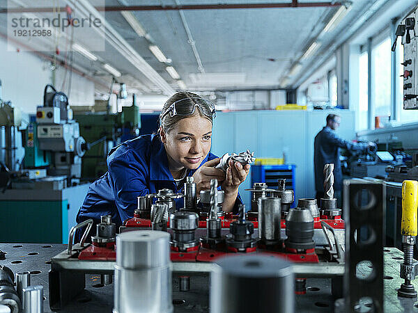 Metallarbeiter lernt  CNC-Werkzeug in der Fabrik zu steuern