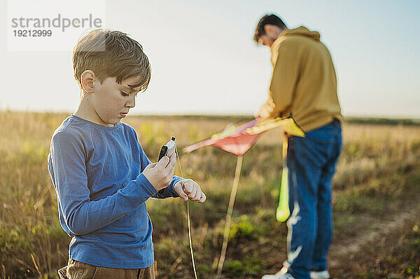 Vater und Sohn mit Drachen im Feld