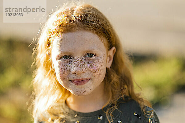 Lächelndes rothaariges Mädchen mit Sommersprossen