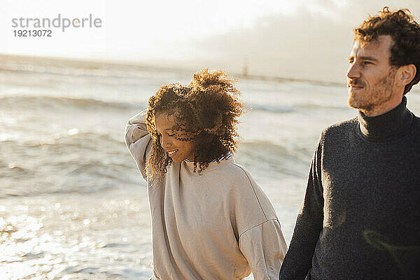 Glückliche Frau und Mann am Strand an einem sonnigen Tag
