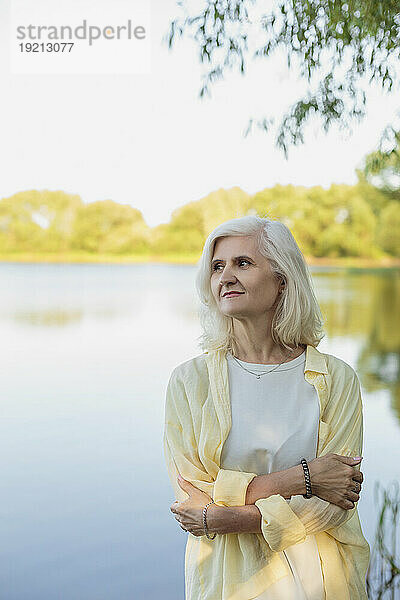 Reife Frau umarmt sich vor dem See