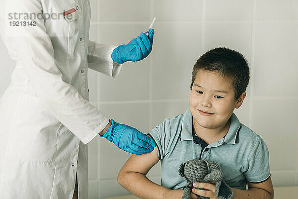 Ärztin gibt einem Jungen in einer medizinischen Klinik eine Impfung