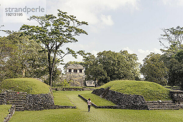 Mann mit Hut läuft durch Maya-Ruinen