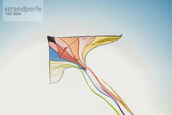 Multi colored kite flying under sky