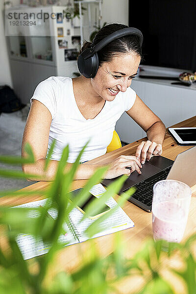 Glücklicher Freiberufler  der zu Hause am Laptop arbeitet