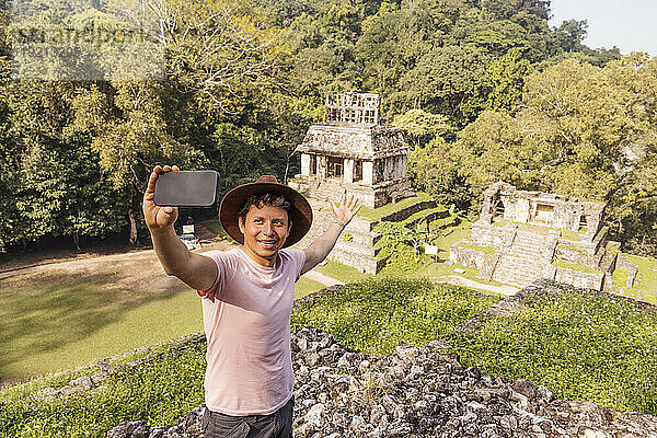 Mann macht Selfie mit Smartphone vor Maya-Ruinen