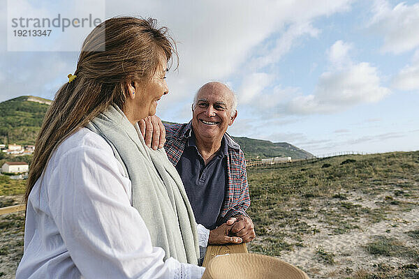 Glücklicher älterer Mann und Frau zusammen unter bewölktem Himmel