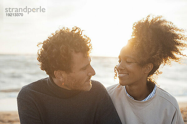 Glückliches Paar  das an einem sonnigen Tag seine Freizeit am Strand verbringt