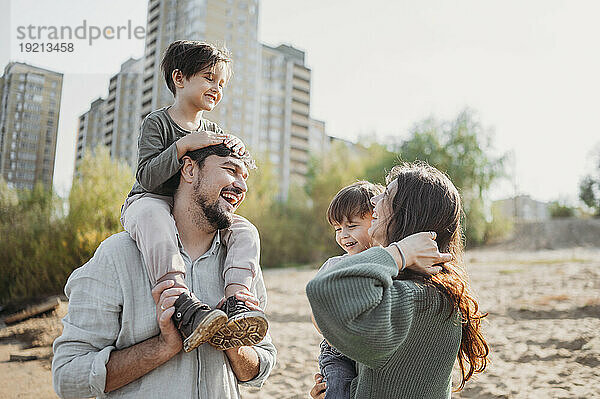 Glückliche Mutter und Vater genießen es mit Kindern am Strand