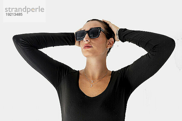 Schöne Frau mit Sonnenbrille vor weißem Hintergrund