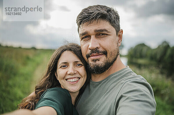 Lächelnde Frau macht Selfie mit Mann