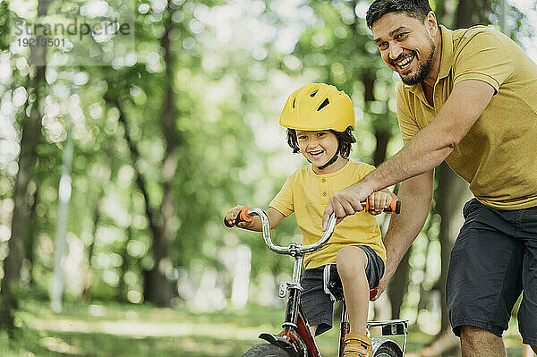 Vater und Sohn genießen Radfahren im Park