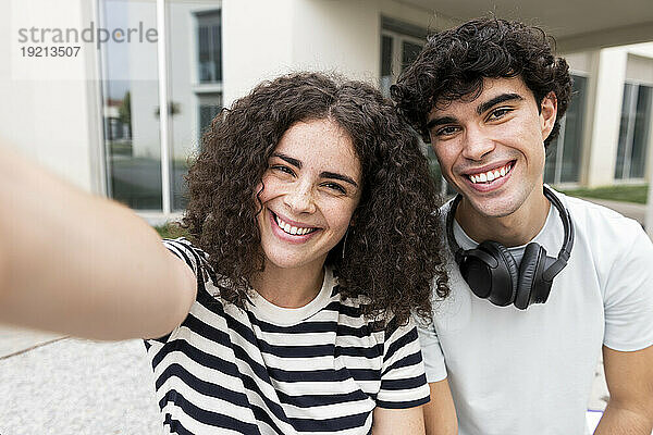 Glückliche Studenten machen Selfie in der Nähe des Gebäudes