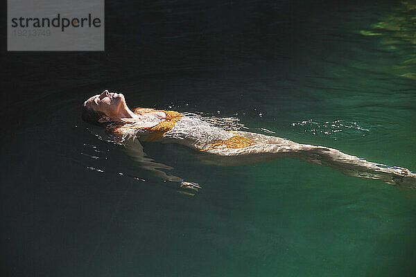 Frau schwimmt auf dem Wasser im Fluss