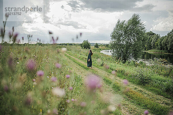 Woman standing on footpath in field