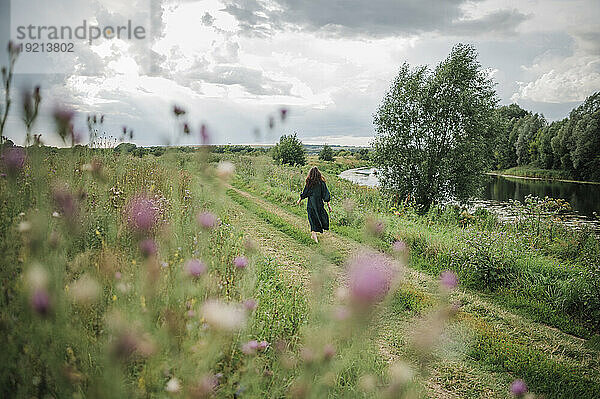 Woman walking near field in village