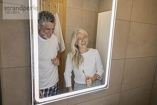 Glückliches Paar lacht zu Hause im Badezimmer