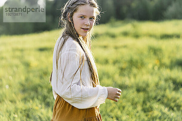 Happy girl standing in meadow