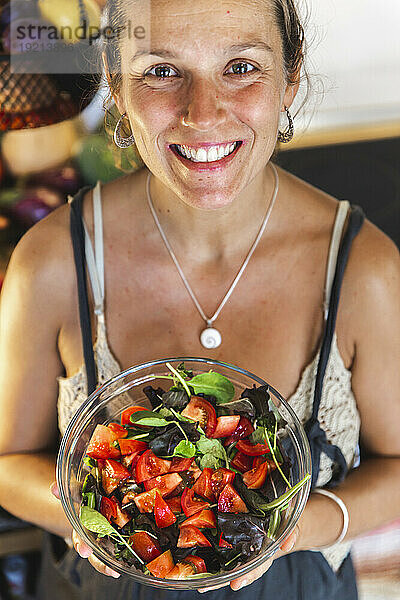 Lächelnde Frau mit Salatschüssel