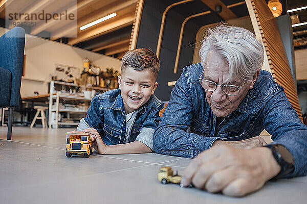 Großvater und Enkel spielen zu Hause mit Spielzeugautos