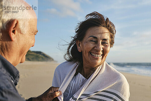 Glückliche ältere Frau und Mann  die an einem sonnigen Tag Spaß am Strand haben