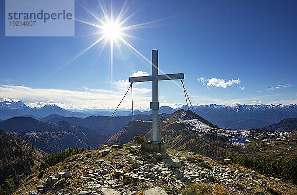 Austria  Salzburger Land  Sun shining over summit cross on Osterhorn mountain