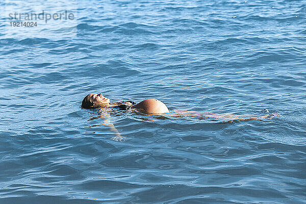 Schwangere Frau schwimmt auf Meerwasser