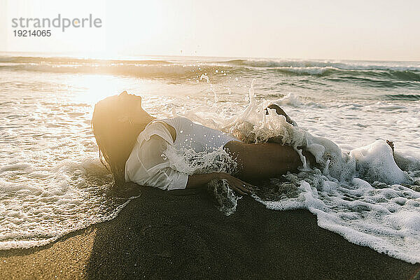 Frau entspannt sich im Sand am Strand