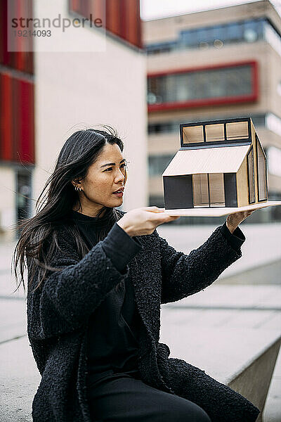 Architekt analysiert Hausmodell vor Bürogebäude