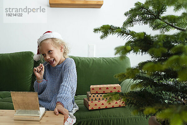 Nachdenkliches Mädchen beißt Bleistift und schreibt Brief an den Weihnachtsmann