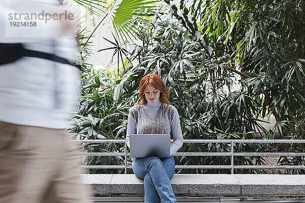 Geschäftsfrau arbeitet am Laptop vor Pflanzen