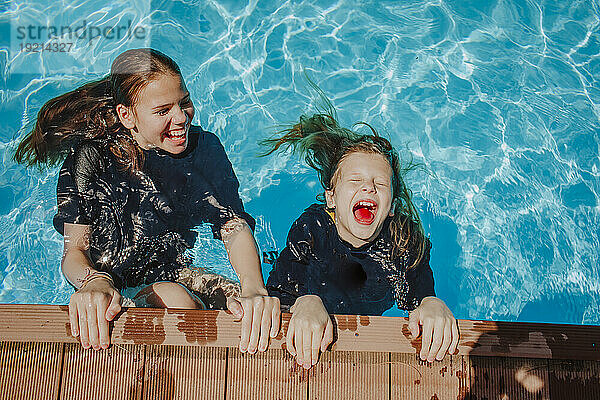 Cheerful friends having fun in swimming pool