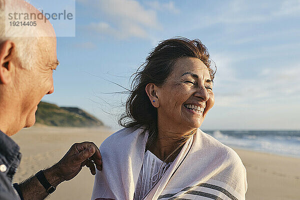 Fröhliche Seniorin genießt es mit Mann am Strand