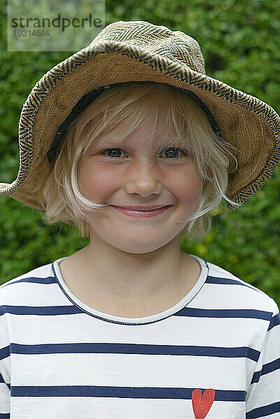 Smiling girl wearing hat in garden
