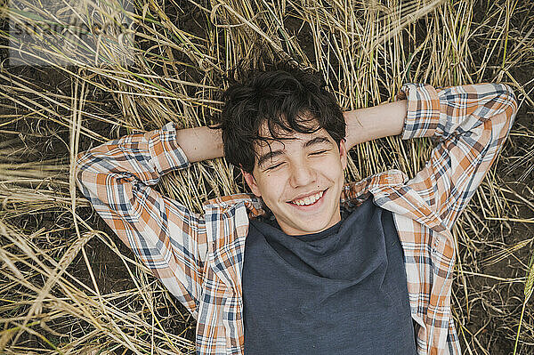 Smiling boy lying on hay