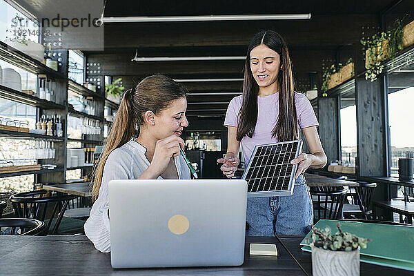 Zwei junge Frauen arbeiten gemeinsam an einem Projekt für nachhaltige Ressourcen im Coworking Space