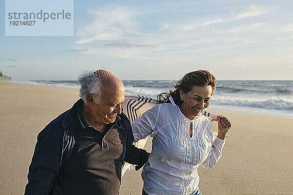 Glückliches Paar  das am Strand spaziert