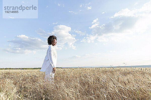 Young woman standing amidst crops in field