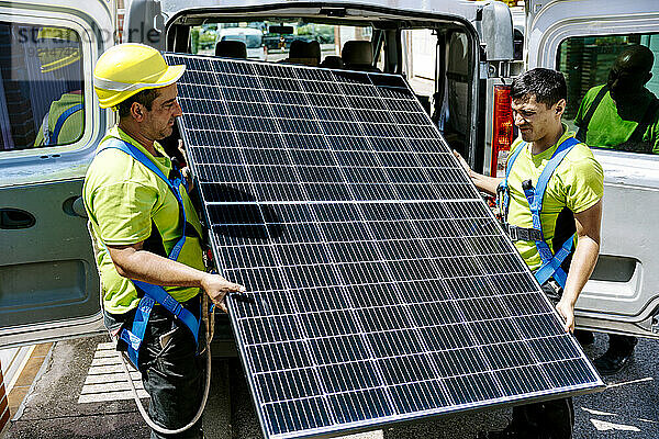 Ingenieure halten Solarpanel an sonnigem Tag