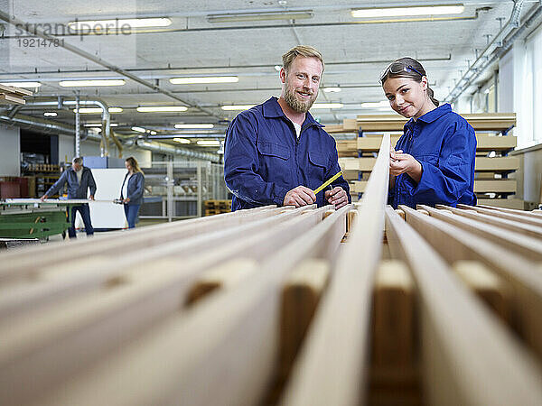 Lächelnder Tischler und Auszubildender in der Fabrik