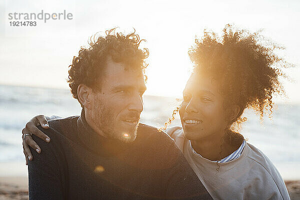 Happy man and woman together at beach on sunny day