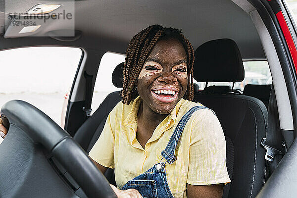 Happy young woman sitting in car