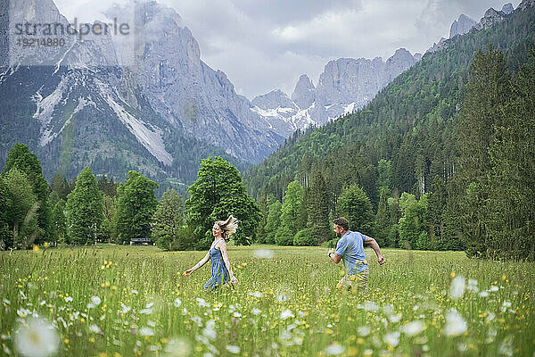 Man and woman running in front of mountains